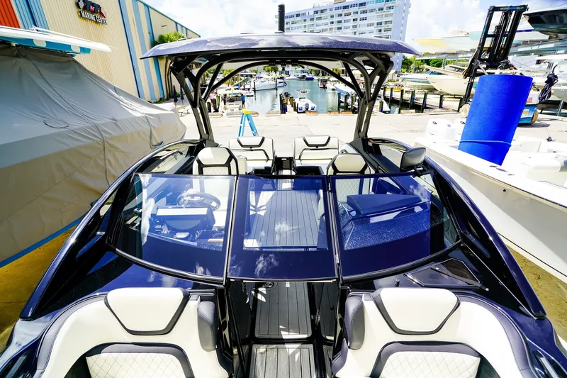 Slide: The Image of 2025 Yamaha Boats 275SD luxury boat docked at marina, showcasing sleek design and spacious interior. - 24