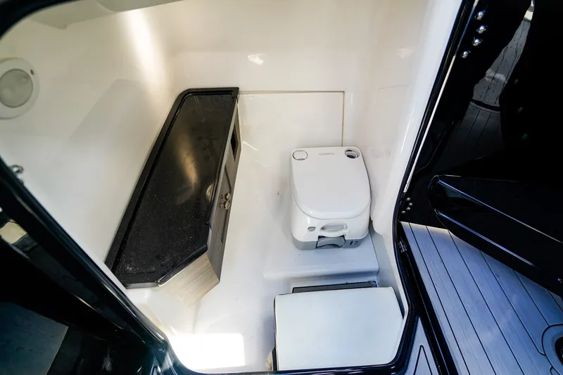 Slide: The Image of Interior of 2025 Yamaha Boats 275SD, featuring a compact marine toilet and countertop. - 15