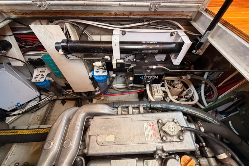Slide: The Image of Engine room of a 2003 Farr 50 Pilot House yacht, showcasing mechanical components and wiring. - 130