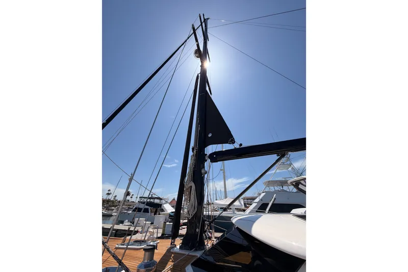 Slide: The Image of Mast of 2003 Farr 50 Pilot House sailboat against clear blue sky at marina. - 17
