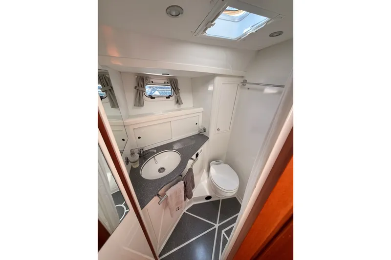Slide: The Image of Bathroom interior of 2003 Farr 50 Pilot House yacht, featuring sink and toilet. - 89