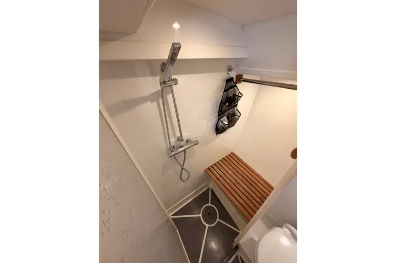 Slide: The Image of Compact shower area in 2003 Farr 50 Pilot House yacht with wooden bench and modern fixtures. - 115