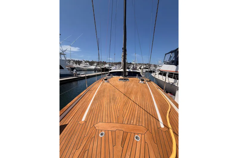Slide: The Image of 2003 Farr 50 Pilot House yacht with wooden deck, docked at marina under clear blue sky. - 29