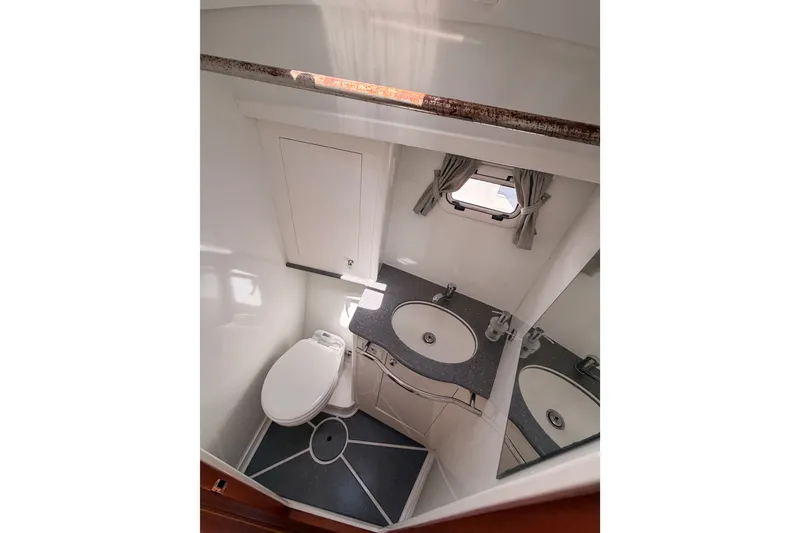 Slide: The Image of Bathroom interior of 2003 Farr 50 Pilot House yacht, featuring sink and toilet. - 81