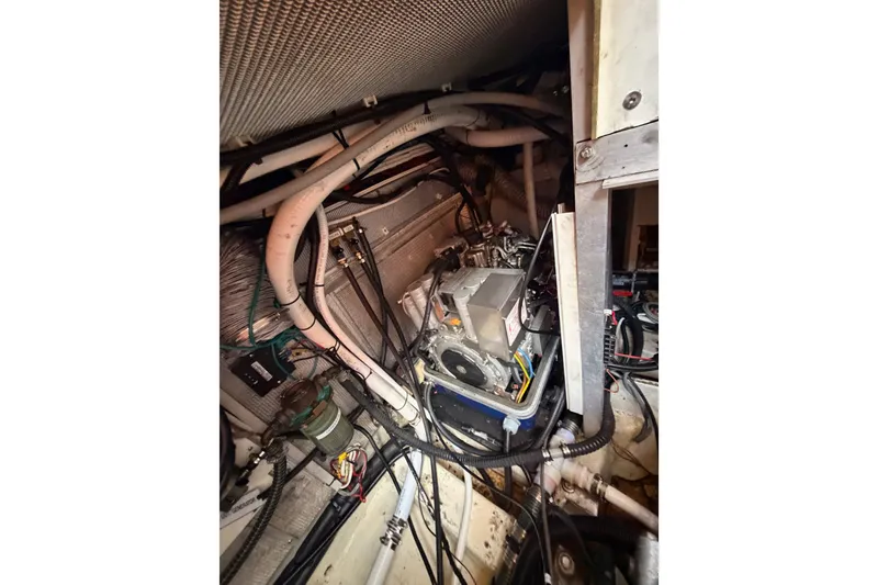 Slide: The Image of Engine room of a 2003 Farr 50 Pilot House yacht, showcasing complex wiring and machinery. - 129