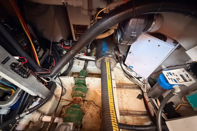 Slide: The Image of Engine room of a 2003 Farr 50 Pilot House yacht, showcasing mechanical components and wiring. - 128