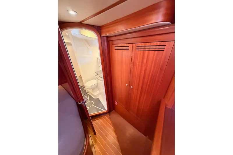 Slide: The Image of Interior of 2003 Farr 50 Pilot House yacht, featuring wooden cabinetry and compact bathroom. - 112