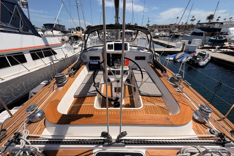 Slide: The Image of 2003 Farr 50 Pilot House yacht with teak deck, docked in a marina under clear skies. - 43