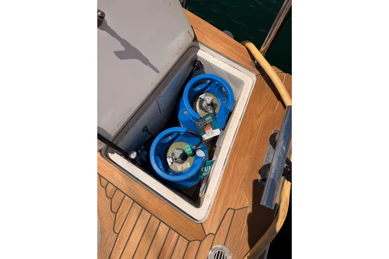 Slide: The Image of Storage compartment on 2003 Farr 50 Pilot House yacht with blue gas cylinders. - 135