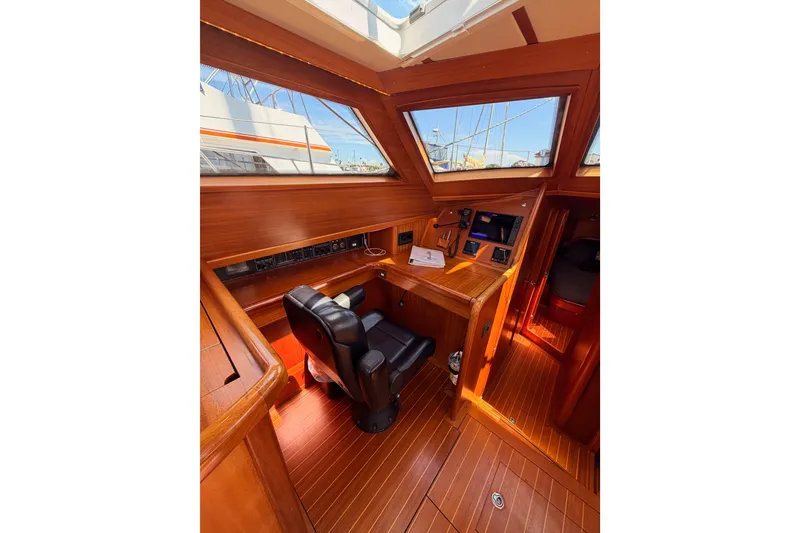 Slide: The Image of Interior of 2003 Farr 50 Pilot House, featuring wooden helm and navigation area. - 64