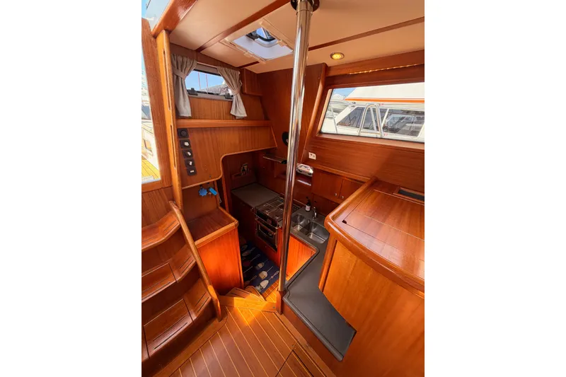 Slide: The Image of Interior of 2003 Farr 50 Pilot House yacht with wooden finishes and compact kitchen area. - 96