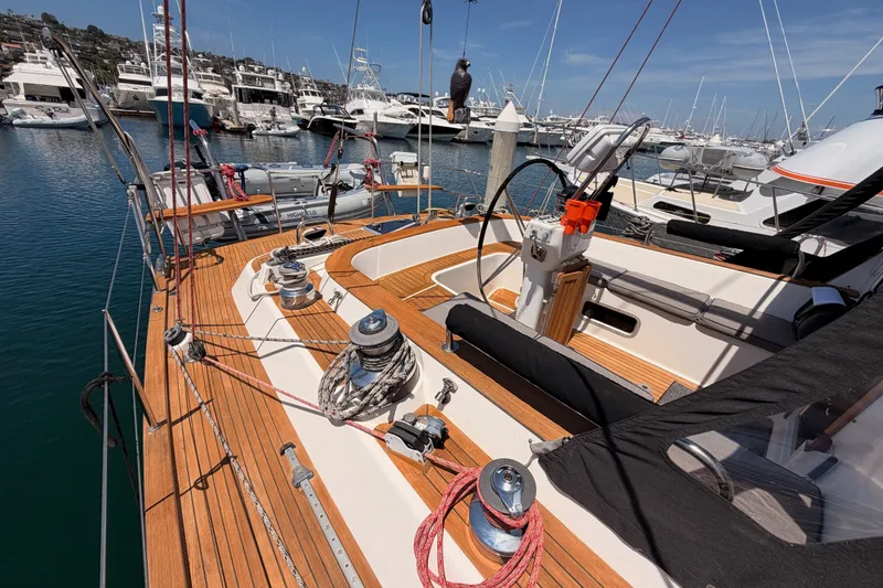 Slide: The Image of 2003 Farr 50 Pilot House yacht docked at marina, showcasing teak deck and steering wheel. - 34