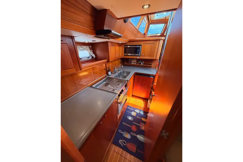Slide: The Image of Luxurious 2003 Farr 50 Pilot House yacht kitchen with wood cabinetry and modern appliances. - 122