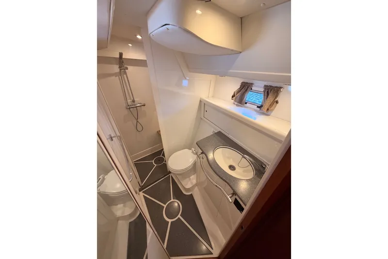 Slide: The Image of Bathroom interior of 2003 Farr 50 Pilot House yacht, featuring shower, toilet, and sink. - 113