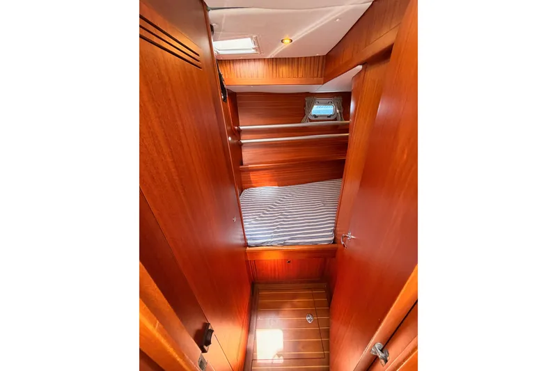 Slide: The Image of Interior cabin of 2003 Farr 50 Pilot House yacht with wooden finish and striped bedding. - 75