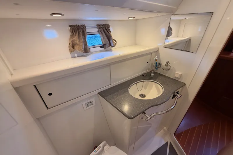 Slide: The Image of Bathroom interior of 2003 Farr 50 Pilot House yacht with sink, mirror, and storage. - 117