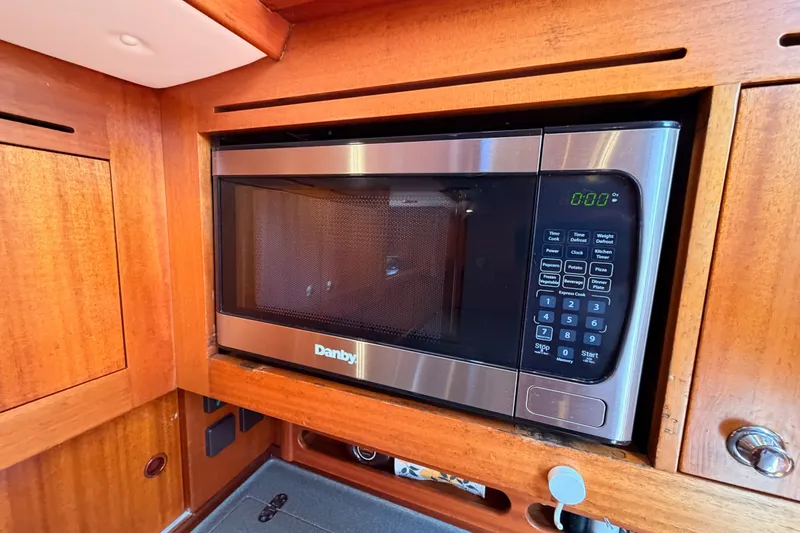Slide: The Image of Microwave in 2003 Farr 50 Pilot House yacht kitchen, featuring wooden cabinetry. - 100