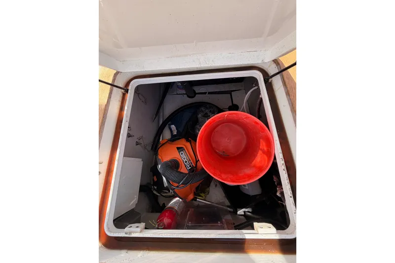 Slide: The Image of Storage compartment on a 2003 Farr 50 Pilot House with tools and a red bucket. - 134