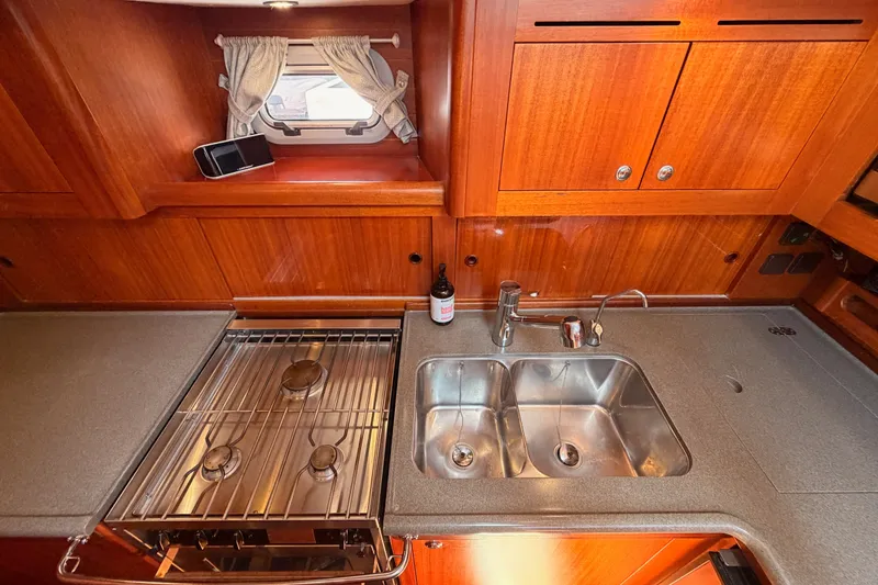 Slide: The Image of Wooden yacht kitchen with dual sink, stove, and window in a 2003 Farr 50 Pilot House. - 101