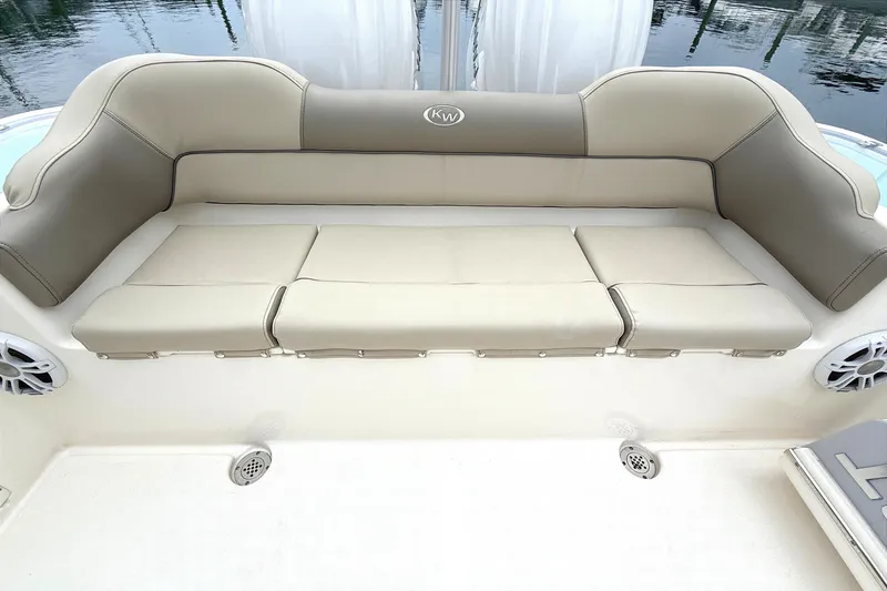 Slide: The Image of 2024 Key West 263 FS boat seating area with beige cushions and integrated speakers. - 15