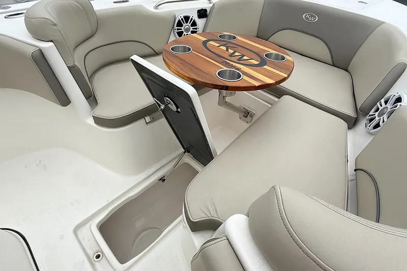 Slide: The Image of 2024 Key West 263 FS boat interior with cushioned seating and wooden table. - 23
