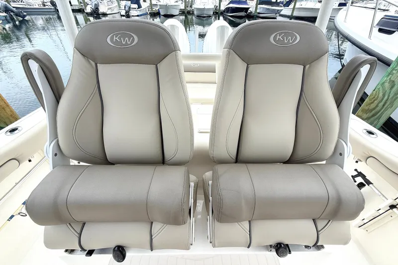 Slide: The Image of 2024 Key West 263 FS boat seats, featuring luxurious gray upholstery at a marina. - 14