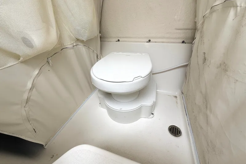 Slide: The Image of 2024 Key West 263 FS boat interior featuring a compact marine toilet setup. - 30