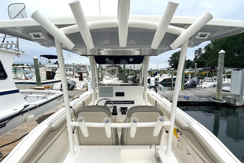 Slide: The Image of 2024 Key West 263 FS boat interior at marina, featuring helm and seating area. - 23
