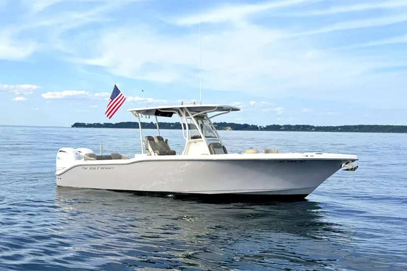 The Image of The image shows a 2024 Key West 263 FS boat on calm water with an American flag. - 0