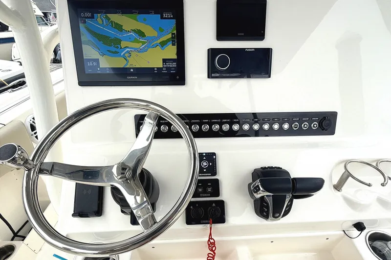Slide: The Image of 2024 Key West 263 FS boat dashboard with steering wheel, navigation screen, and controls. - 7