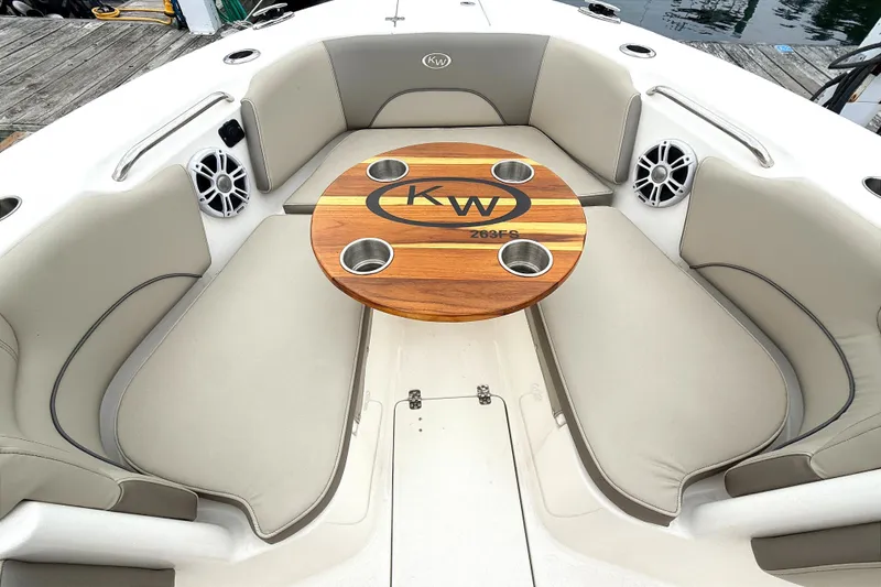 Slide: The Image of 2024 Key West 263 FS boat interior with cushioned seating and wooden table. - 11