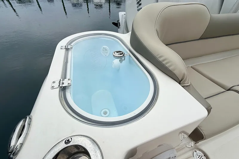 Slide: The Image of 2024 Key West 263 FS boat with livewell and cushioned seating by the water. - 17