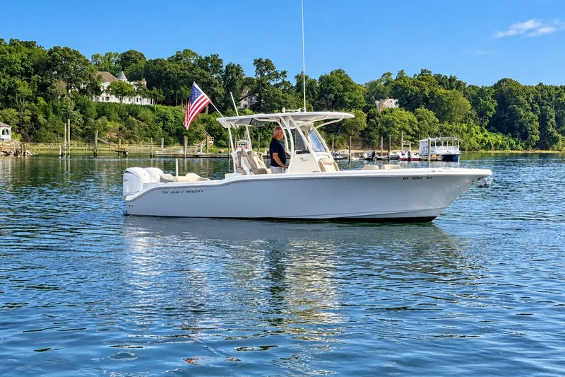 Slide: The Image of 2024 Key West 263 FS boat on calm water with American flag. - 3