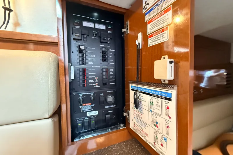 Slide: The Image of Electrical panel inside 2013 Sea Ray Sundancer 370 yacht, featuring switches and safety instructions. - 40