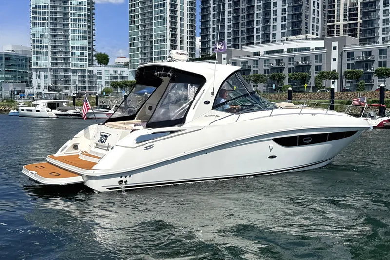 Slide: The Image of 2013 Sea Ray Sundancer 370 yacht cruising near modern city waterfront. - 1