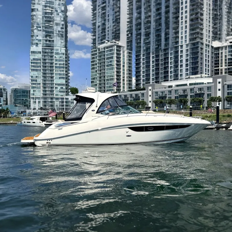 The Image of 2013 Sea Ray Sundancer 370 yacht cruising near modern city skyline. - 0