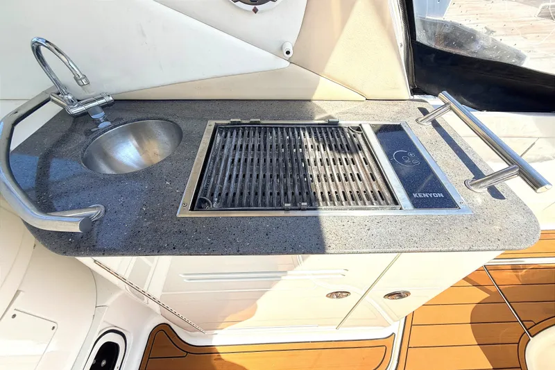 Slide: The Image of Outdoor kitchenette on 2013 Sea Ray Sundancer 370 with sink and Kenyon grill. - 9