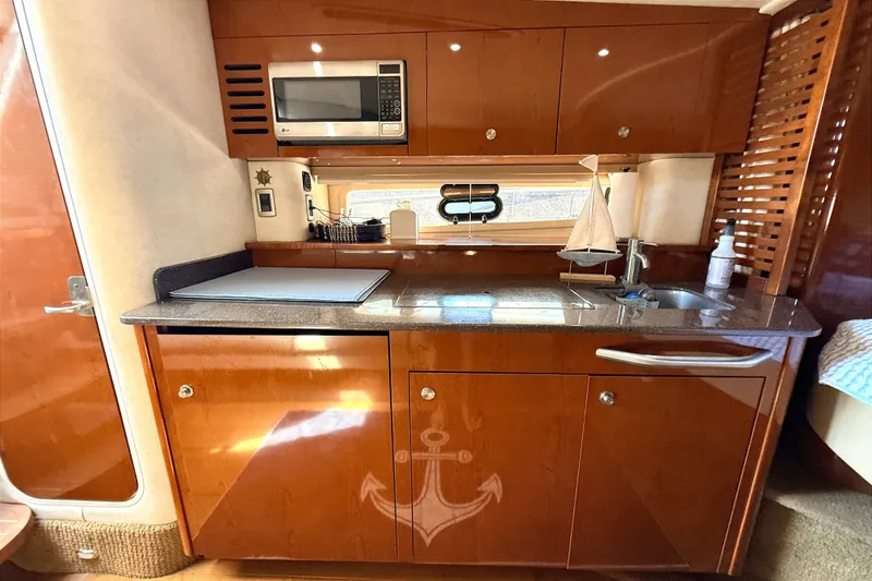 Slide: The Image of Luxurious 2013 Sea Ray Sundancer 370 yacht kitchen with wood cabinetry and modern appliances. - 19