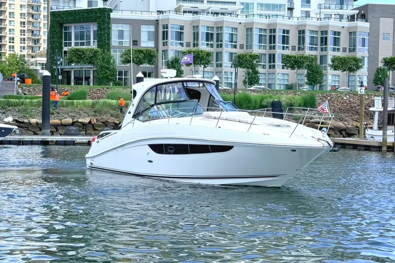 Slide: The Image of 2013 Sea Ray Sundancer 370 yacht docked near modern waterfront buildings. - 2