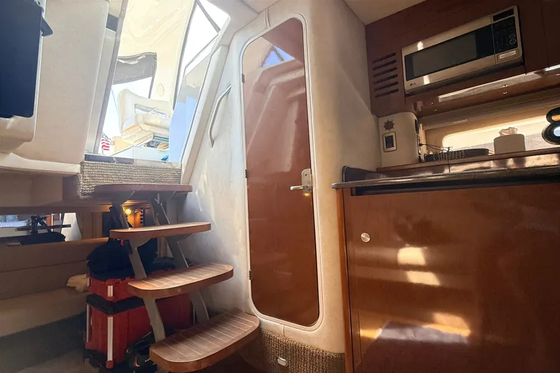 Slide: The Image of Interior of 2013 Sea Ray Sundancer 370 yacht, featuring stairs and kitchenette area. - 17