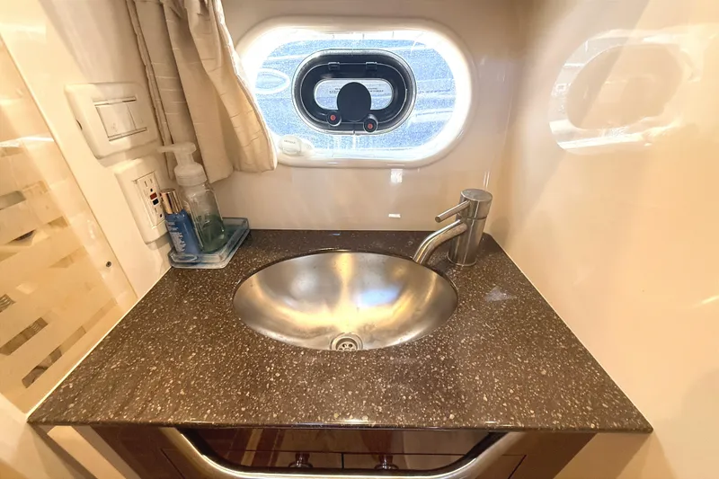 Slide: The Image of Luxurious bathroom sink in 2013 Sea Ray Sundancer 370 yacht, featuring modern fixtures and porthole window. - 38