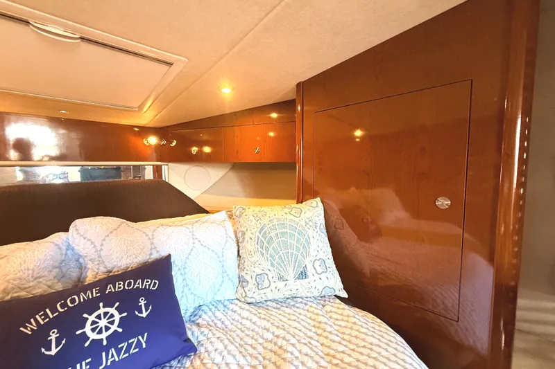 Slide: The Image of Luxurious cabin interior of 2013 Sea Ray Sundancer 370 with plush bedding and wooden accents. - 30