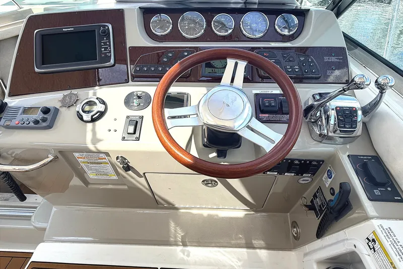 Slide: The Image of Cockpit of 2013 Sea Ray Sundancer 370 with steering wheel and control panel. - 13