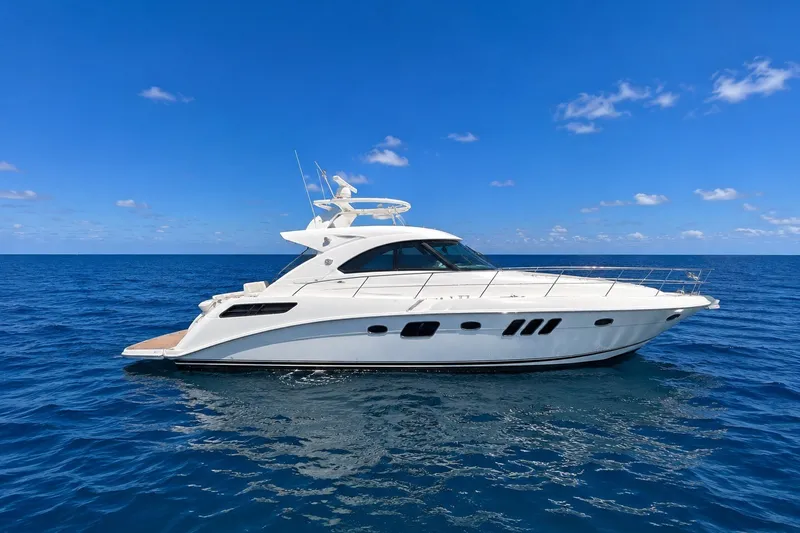 The Image of 2010 Sea Ray Sundancer 540 yacht cruising on open blue ocean under clear sky. - 1