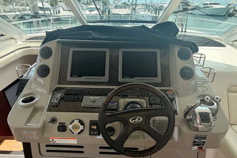 Slide: The Image of Cockpit of 2010 Sea Ray Sundancer 540 yacht with dual navigation screens and steering wheel. - 22
