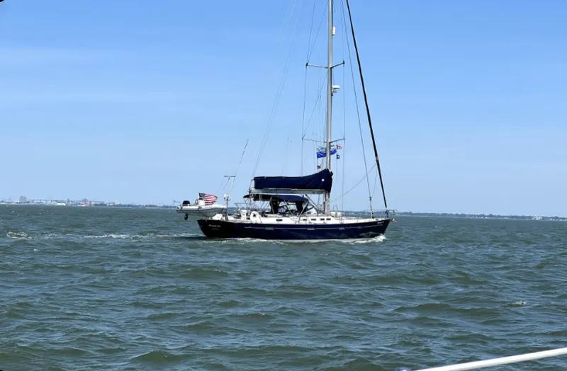 The Image of A 2005 Beneteau 57 sailing on open water under a clear blue sky. - 0