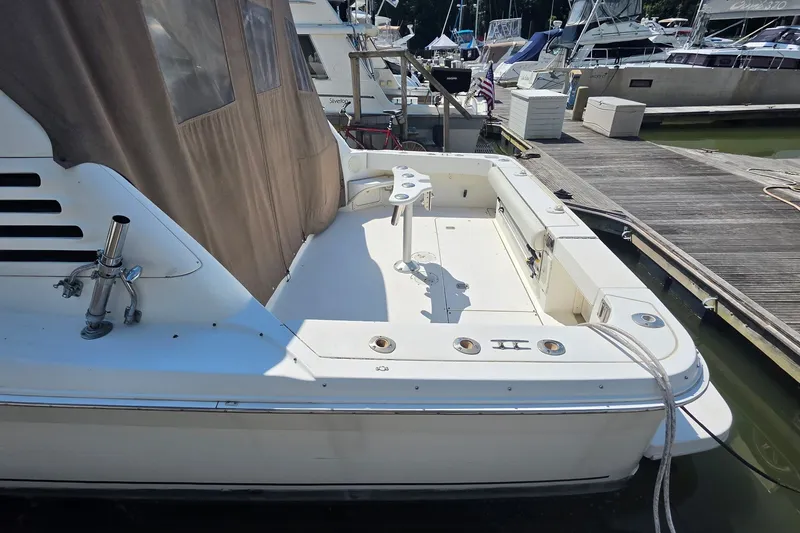 Slide: The Image of 1998 Sea Ray 340 Amberjack boat docked, featuring spacious deck and fishing rod holders. - 4