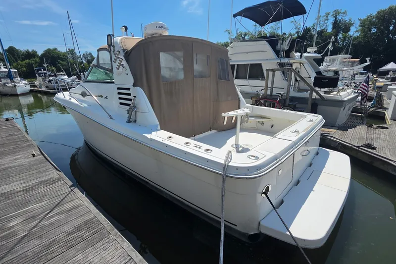Slide: The Image of 1998 Sea Ray 340 Amberjack docked at marina, featuring spacious deck and sleek design. - 3