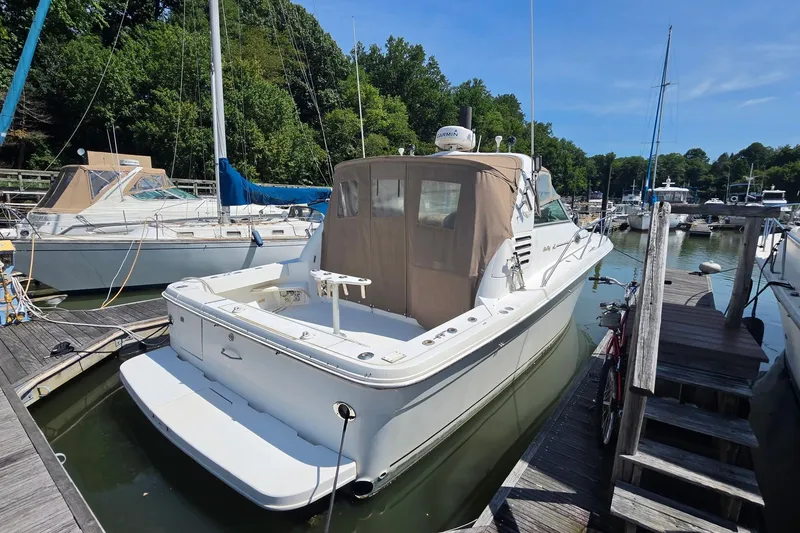 Slide: The Image of 1998 Sea Ray 340 Amberjack docked at a marina, surrounded by other boats. - 1