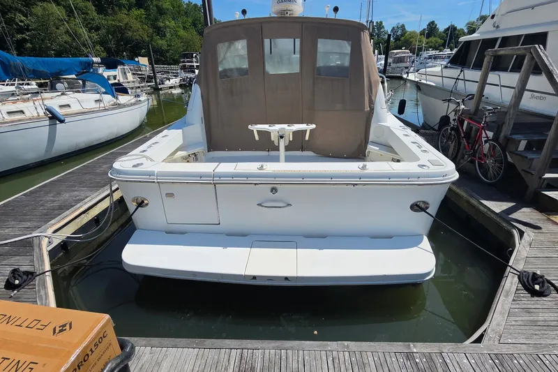 Slide: The Image of 1998 Sea Ray 340 Amberjack docked at marina, rear view with surrounding boats. - 2